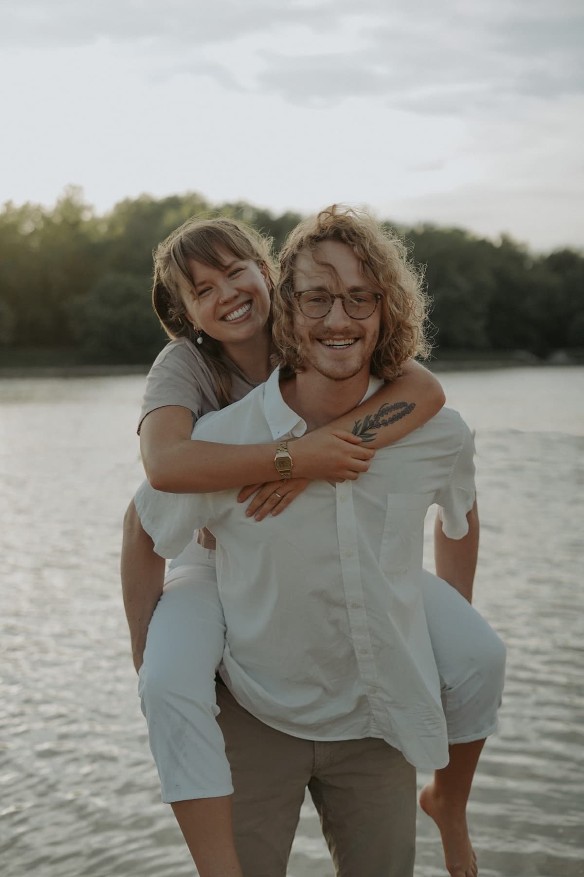Izzy and Josh smiling together by a lake